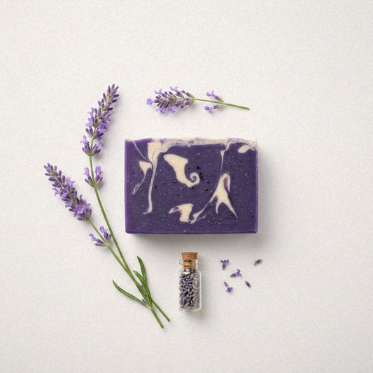 Lavender goat milk soap bar flat lay with lavender sprigs and a small vial