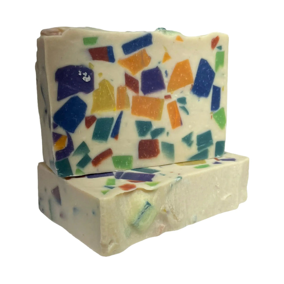 Close-up of Monkey Farts goat milk soap showing colorful mosaic soap pieces in a creamy bar