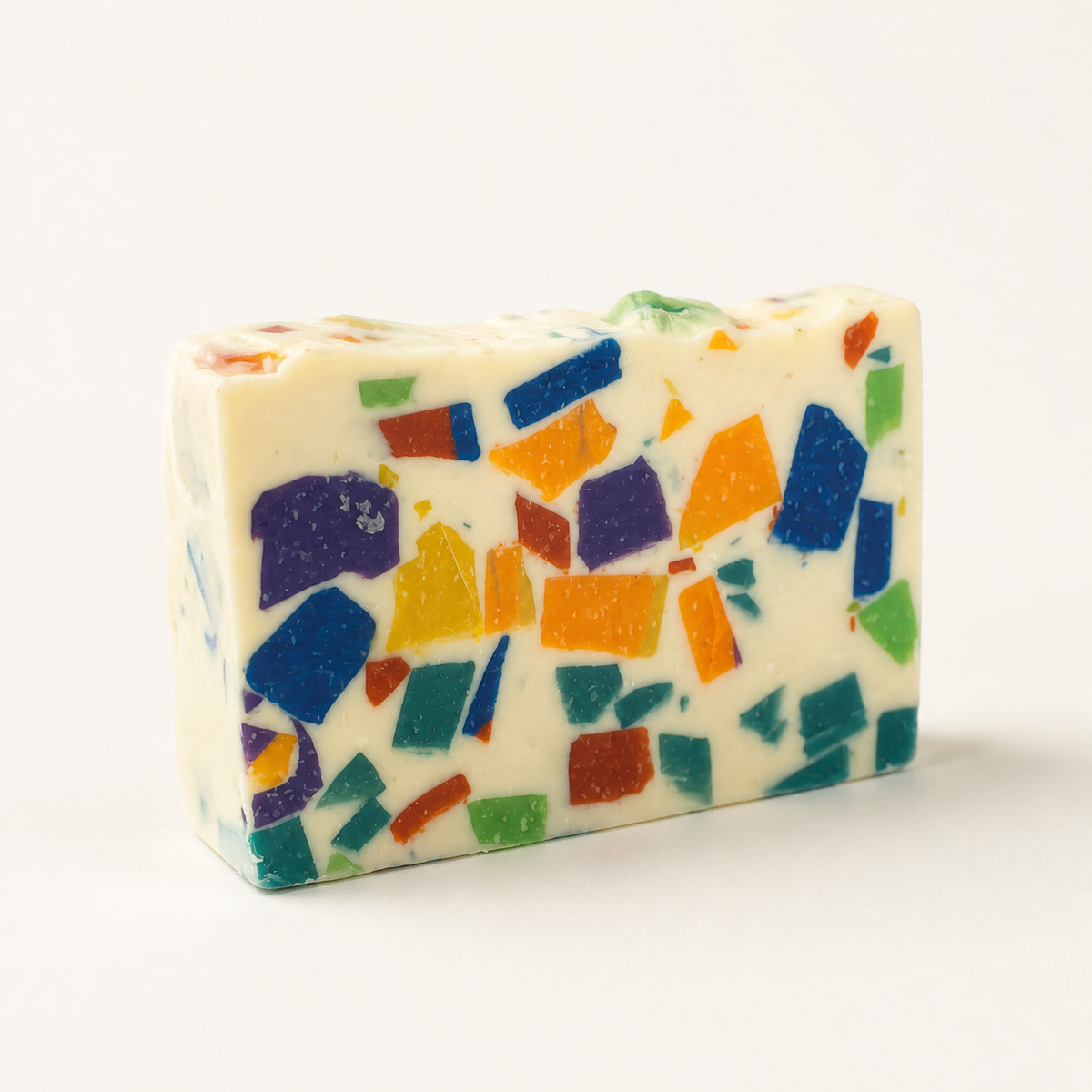 Monkey Farts goat milk soap bar, cream base with purple, blue, orange, yellow, green, red and teal confetti chunks
