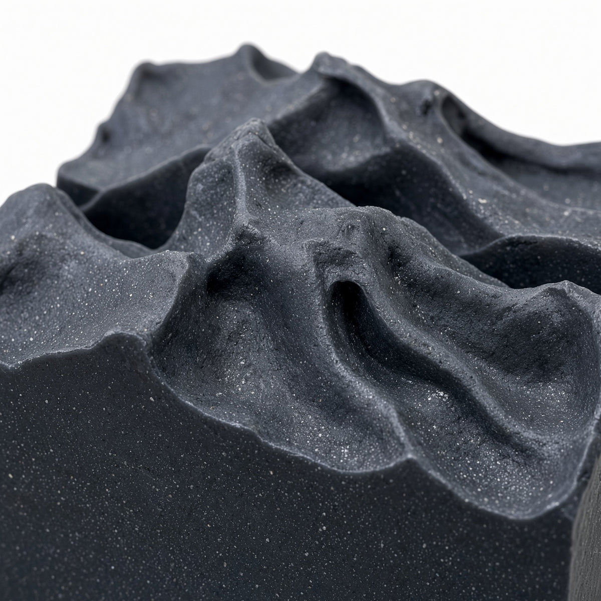 Close-up of the swirled top texture on a black charcoal goat milk soap bar