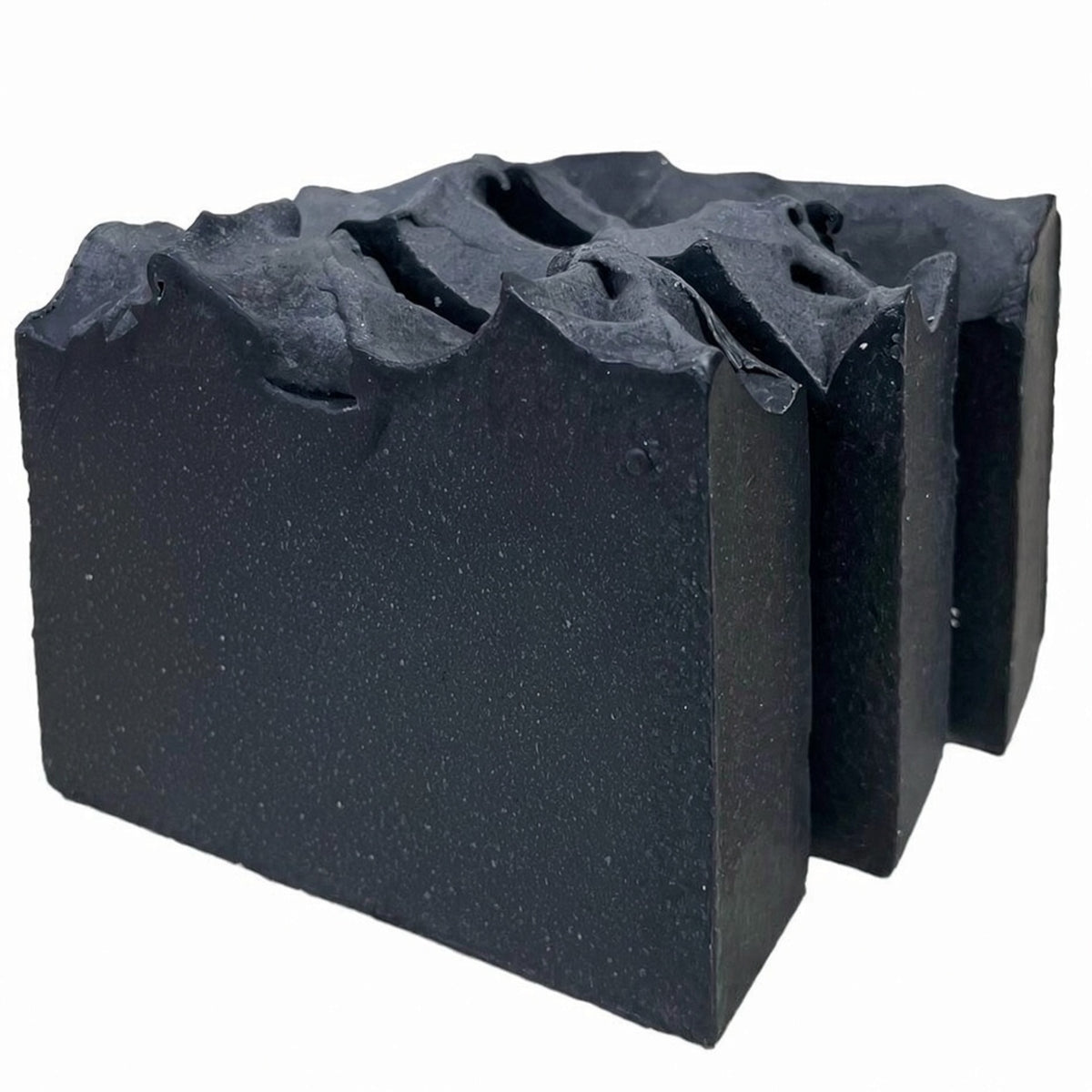Row of charcoal goat milk soap bars with wavy sculpted tops