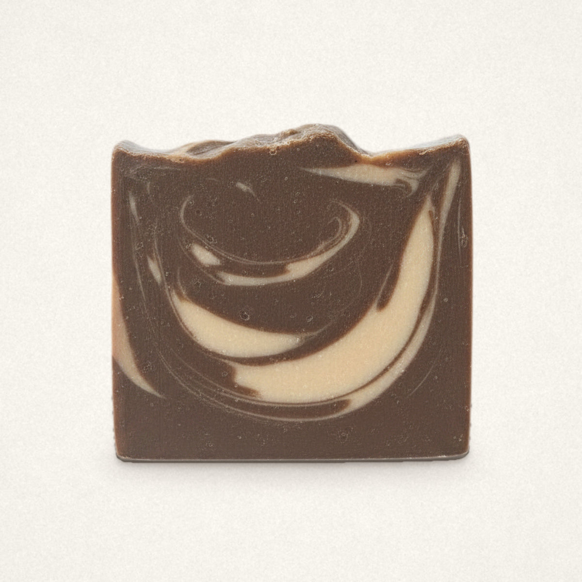 Almond Biscotti goat milk soap bar with chocolate brown and cream swirls on an off-white background
