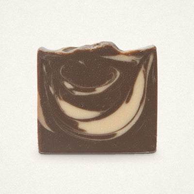 Almond Biscotti goat milk soap bar with chocolate brown and cream swirls on an off-white background