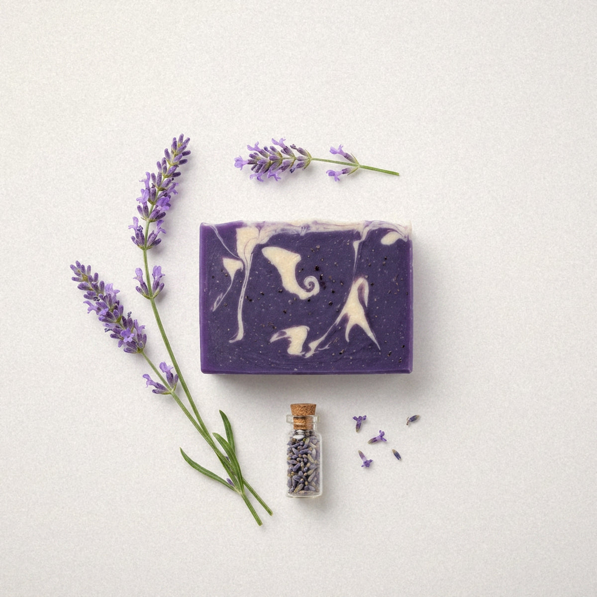 Lavender goat milk soap bar flat lay with lavender sprigs and a small vial